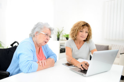 mature woman helping assisted elderly senior female with administrative procedures